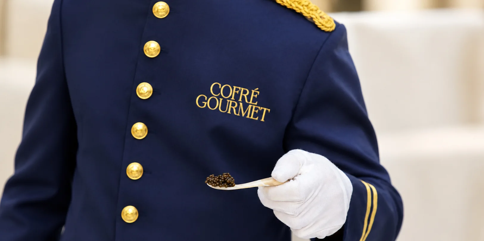 Detalle de una cucharilla de caviar servida por personal uniformado