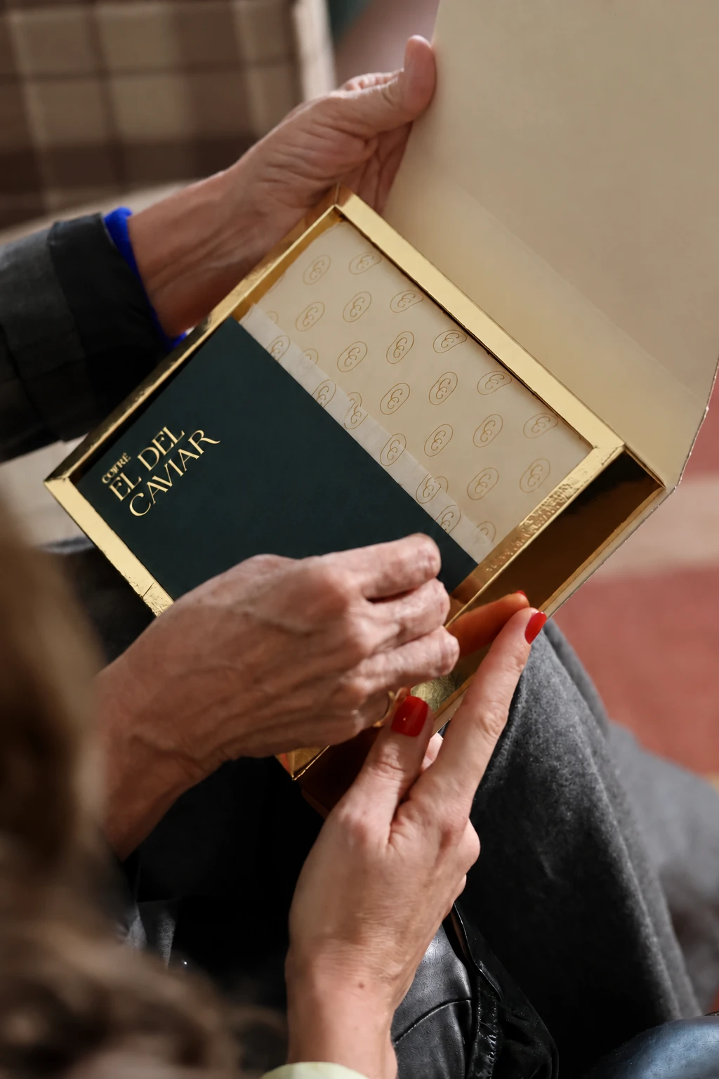 Opening a COFRÉ gift with its gold presentation.