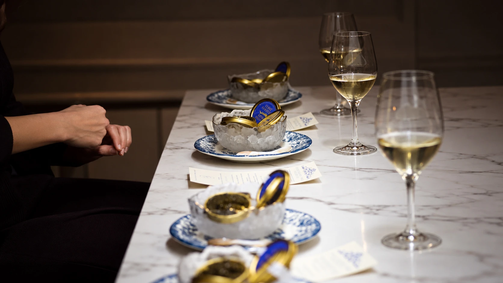 Servicio de caviar Cofré y copas en una mesa de mármol